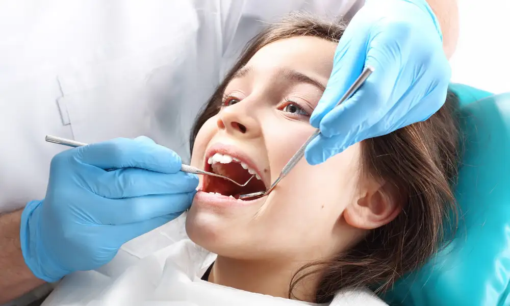 Dentist in Burlington at Maple Mews Dental applying dental sealants to child's teeth